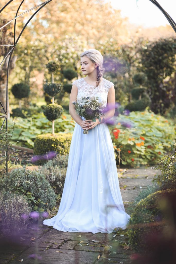 Bridesmaid looking to side in garden | Journey to the Centre of the Earth | modern ethereal winter styled bridal shoot by Hanami Dream | agate | marble | airplants | tulle | pale blue | gold | Oxleaze Barn | Gloucestershire | October 2017 | Photography by Squib Photography www.squibphotography.co.uk