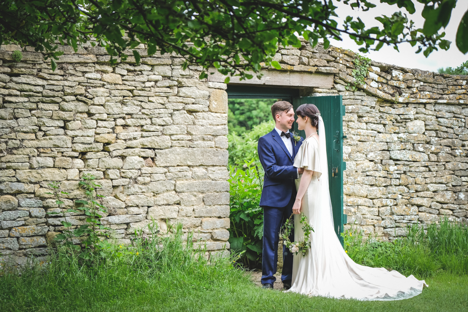 Couple by walled garden | The Secret Garden | modern Edwardian styled bridal shoot by Hanami Dream | greenery | perspex | Cogges Manor Farm | Witney | May 2017 | Photography by Squib Photography www.squibphotography.co.uk