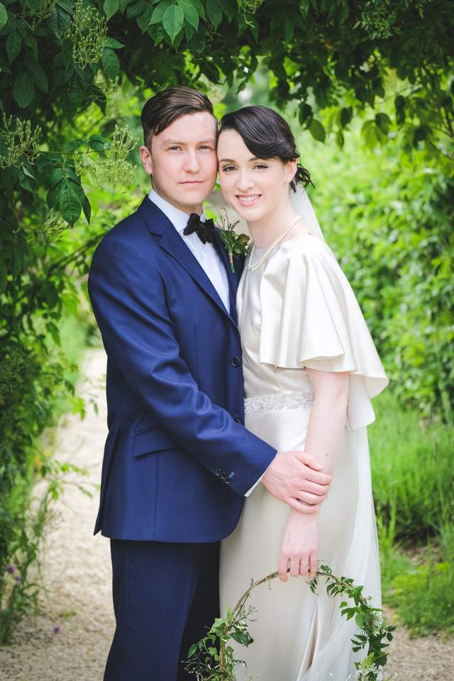 Couple under greenery arch | The Secret Garden | modern Edwardian styled bridal shoot by Hanami Dream | greenery | perspex | Cogges Manor Farm | Witney | May 2017 | Photography by Squib Photography www.squibphotography.co.uk