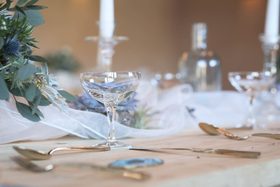Champagne coupe glasses and gold cutlery | Journey to the Centre of the Earth | modern ethereal winter styled bridal shoot by Hanami Dream | agate | marble | airplants | tulle | pale blue | gold | Oxleaze Barn | Gloucestershire | October 2017 | Photography by Squib Photography www.squibphotography.co.uk