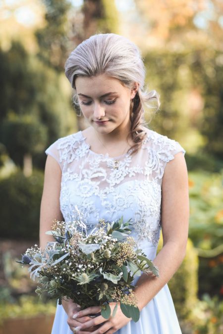 Bridesmaid looking down in garden | Journey to the Centre of the Earth | modern ethereal winter styled bridal shoot by Hanami Dream | agate | marble | airplants | tulle | pale blue | gold | Oxleaze Barn | Gloucestershire | October 2017 | Photography by Squib Photography www.squibphotography.co.uk