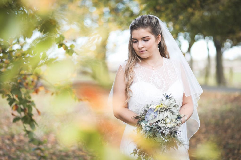 Bride looking down in the garden | Journey to the Centre of the Earth | modern ethereal winter styled bridal shoot by Hanami Dream | agate | marble | airplants | tulle | pale blue | gold | Oxleaze Barn | Gloucestershire | October 2017 | Photography by Squib Photography www.squibphotography.co.uk